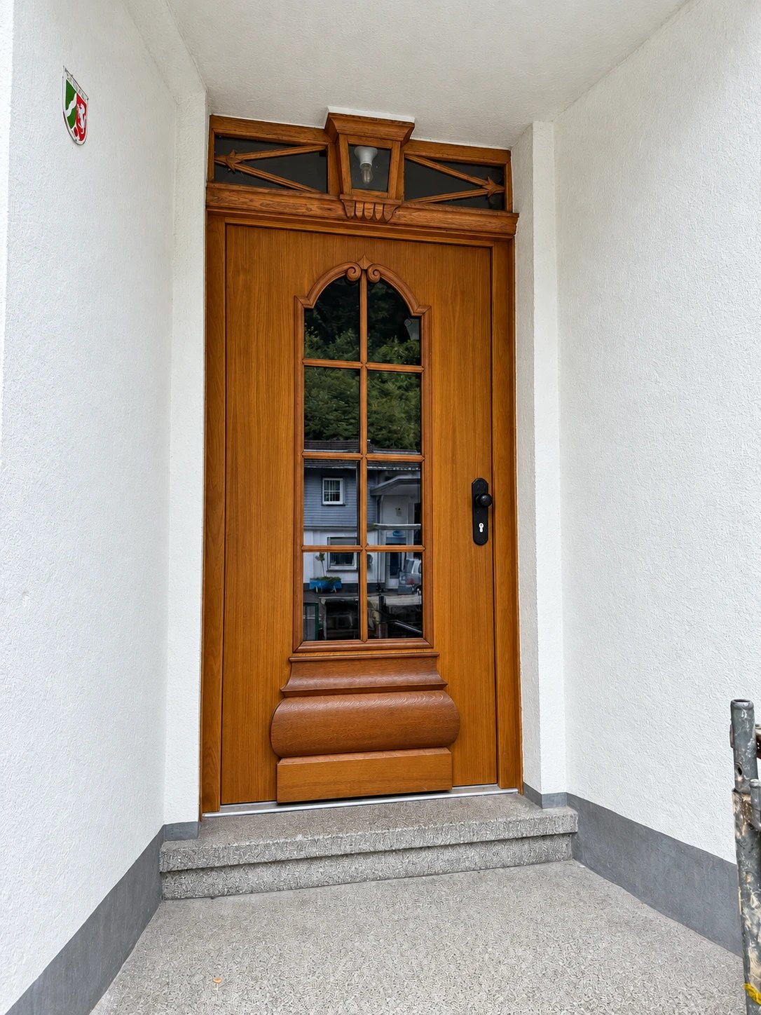 Klassische Haustür in Holzoptik mit Sprossenfenster und Oberlicht